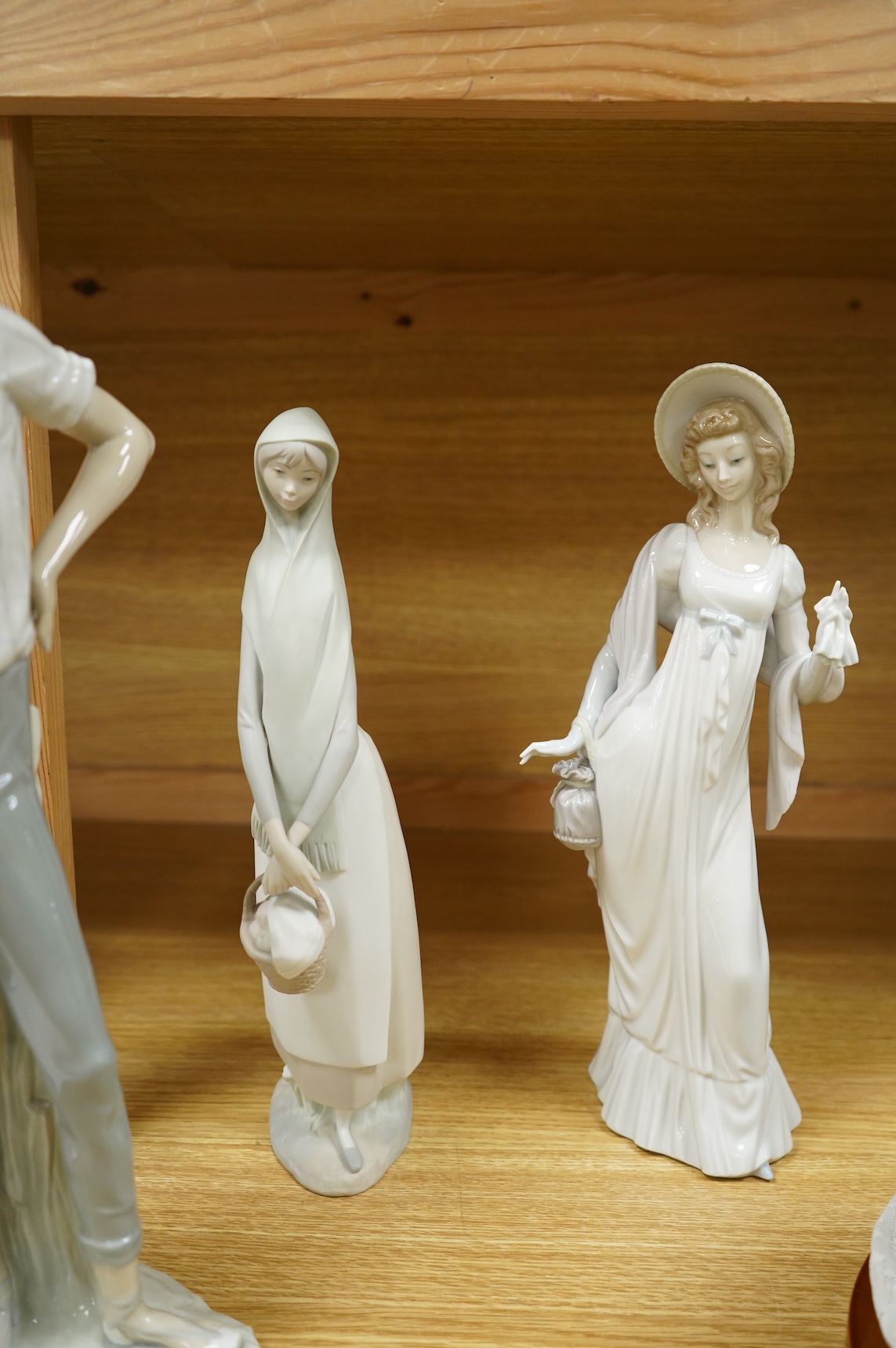 A group of Lladro figures: Bust of a lady in a lace veil, Girl with a basket, Lady holding gloves and a male reaper, 43cm high - 4 items, some boxed.